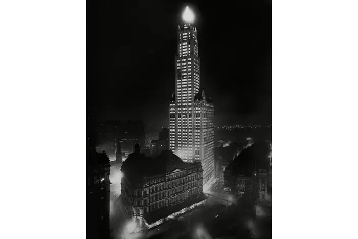 Woolworth Building towers over the City Hall Post Office and Courthouse at night, 1914-1919. Photo was taken from the new Municipal Building completed in 1914. The courthouse was demolished in 1939 and replaced with the City Hall Park